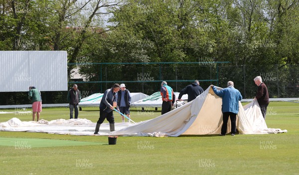110521 - Glamorgan Second XI v Gloucestershire Second XI, Second XI Championship - Volunteers at Newport Cricket Club remove the covers ahead of play at the ground