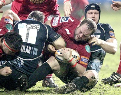 090212 - Glasgow Warriors v Scarlets - RaboDirect Pro 12Glasgow Warriors' Ryan Grant (L) and Rob Verbakel (R) tackle Scarlets' Peter Edwards (2R)