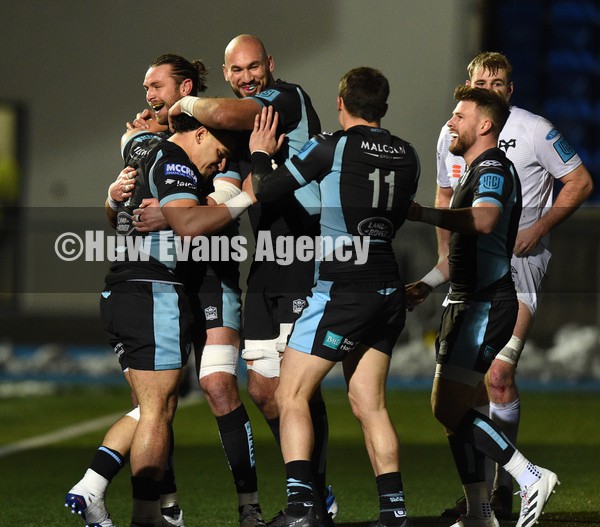 080122 - Glasgow Warriors v Ospreys - United Rugby Championship - Sione Tuipulotu of Glasgow celebrates with Ryan Wilson and Kiran McDonald after racing through for his second try