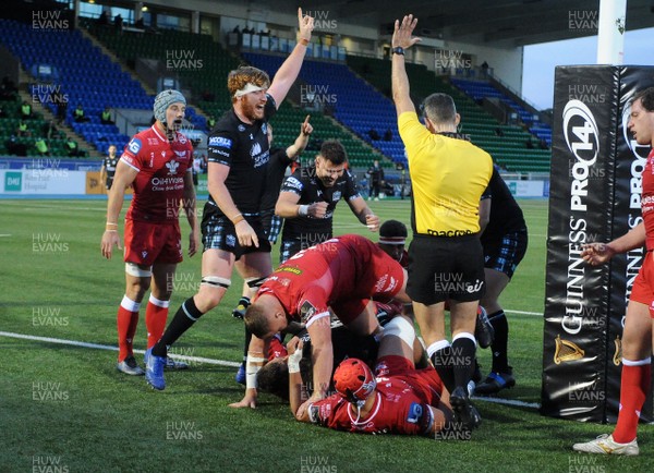 111020 - Glasgow Warriors v Scarlets - Guinness PRO14 - Ryan Wilson of Glasgow (6) crashes over for a try early in the second half signalled by referee Frank Murphy as Ali Price and Rob Harley (L) celebrate