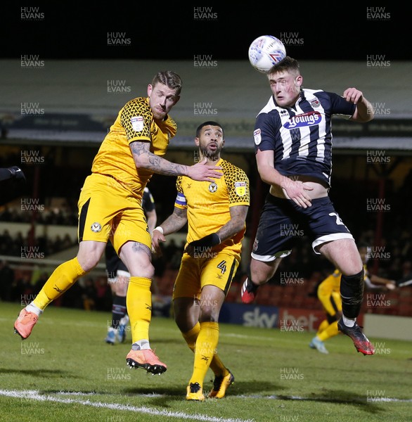 250220 - Grimsby Town v Newport County - Sky Bet League 2 - Mattie Pollock of Grimsby Town heads away the danger from Scot Bennett of Newport County