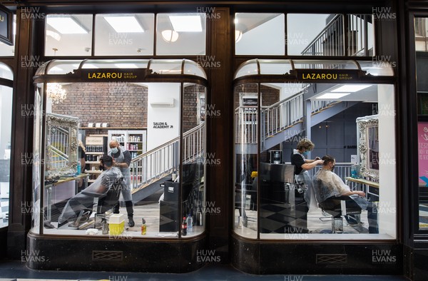 150321 - Customers at Lazarou in Cardiff city centre get haircuts as barbers and hairdressers on the first day they are allowed to reopen in Wales after the Welsh Government relaxed COVID19 lockdown restrictions in the country