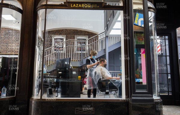 150321 - Customers at Lazarou in Cardiff city centre get haircuts as barbers and hairdressers on the first day they are allowed to reopen in Wales after the Welsh Government relaxed COVID19 lockdown restrictions in the country