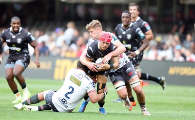 251025 - Hollywoodbets Sharks v Scarlets - United Rugby Championship -  Taine Plumtree of the Scarlets tackling Edwilll van der Merwe of the Hollywoodbets Sharks