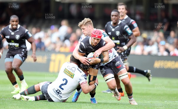 251025 - Hollywoodbets Sharks v Scarlets - United Rugby Championship -  Taine Plumtree of the Scarlets tackling Edwilll van der Merwe of the Hollywoodbets Sharks
