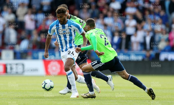 250818 - Huddersfield Town v Cardiff City - Premier League - Steve Mounie of Huddersfield Town is challenged by V�ctor Camarasa of Cardiff City