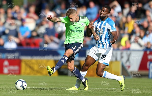 250818 - Huddersfield Town v Cardiff City - Premier League - Joe Bennett of Cardiff City is challenged by Isaac Mbenza of Huddersfield Town