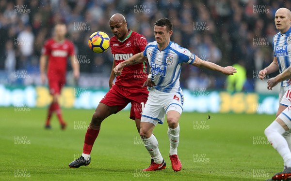 100318 - Huddersfield Town v Swansea City - Premier League - Andre Ayew of Swansea is tackled by Jonathan Hogg of Huddersfield