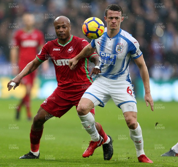 100318 - Huddersfield Town v Swansea City - Premier League - Andre Ayew of Swansea is tackled by Jonathan Hogg of Huddersfield