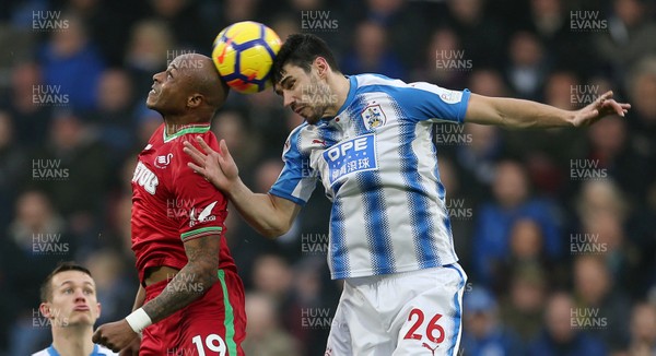 100318 - Huddersfield Town v Swansea City - Premier League - Andre Ayew of Swansea and Christopher Schindler of Huddersfield go up for the ball