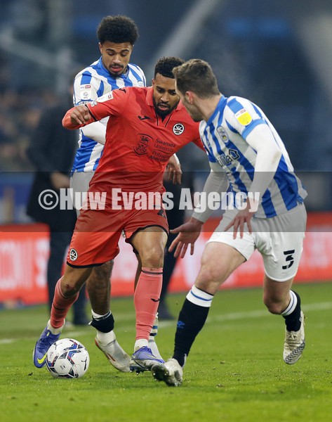 150122 - Huddersfield Town v Swansea City - Sky Bet Championship - Cyrus Christie of Swansea ploughs through Huddersfield defence 