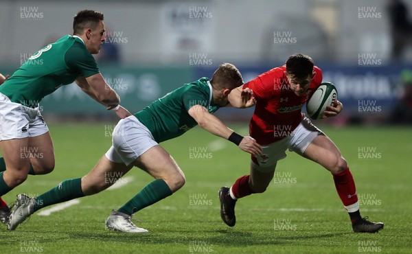 230218 - Ireland U20s v Wales U20s - Natwest 6 Nations - Tommy Rogers of Wales is tackled by Michael Silvester of Ireland