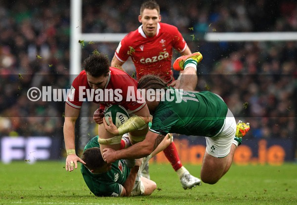 050222 - Ireland v Wales - Guinness Six Nations - Taine Basham of Wales is tackled by Garry Ringrose and James Hume of Ireland