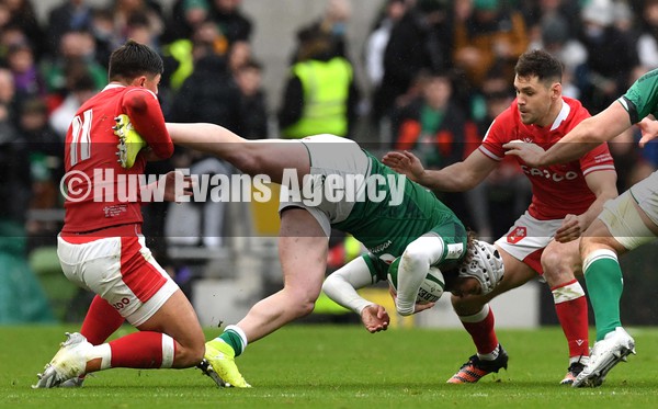 050222 - Ireland v Wales - Guinness Six Nations - Mack Hansen of Ireland is tackled by Louis Rees-Zammit and Tomos Williams of Wales