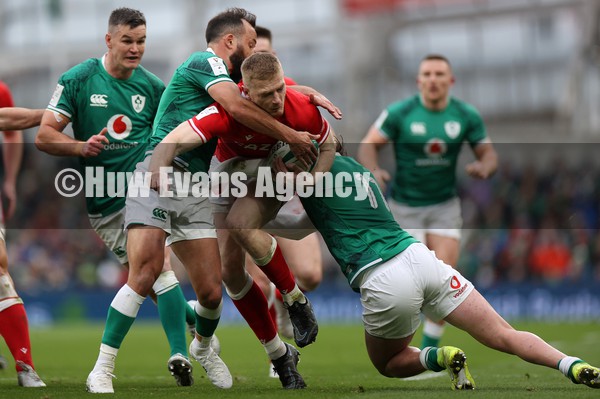 050222 - Ireland v Wales - Guinness Six Nations Championship - Johnny McNicholl of Wales is tackled by Jamison Gibson-Park and Mack Hansen of Ireland