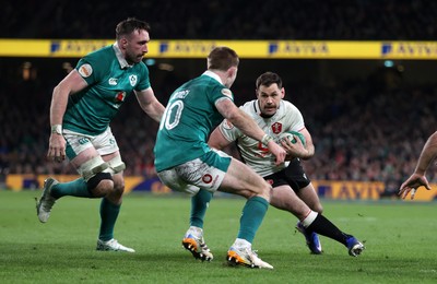 060326 - Ireland v Wales - Guinness Six Nations Championship - Tomos Williams of Wales is challenged by Jack Crowley of Ireland 