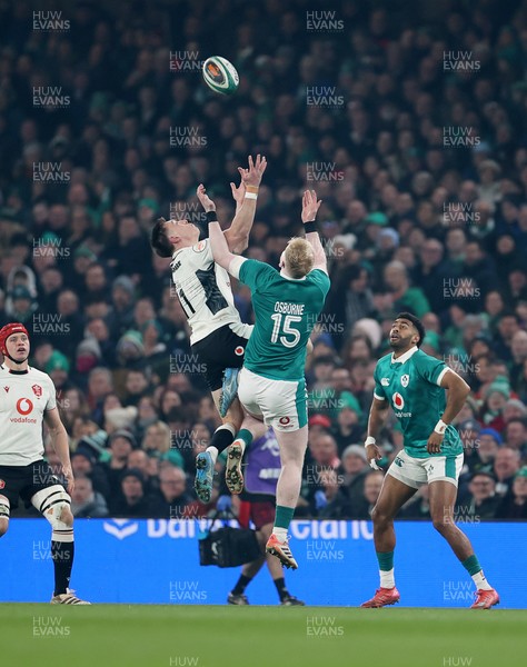 060326 - Ireland v Wales - Guinness Six Nations Championship - Josh Adams of Wales goes for the high ball with Jamie Osborne of Ireland 