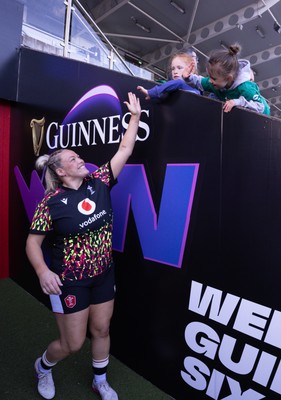 090526 - Ireland v Wales, 2026 Guinness Women’s 6 Nations - Kelsey Jones of Wales high fives a young fan as she makes her way to the pitch