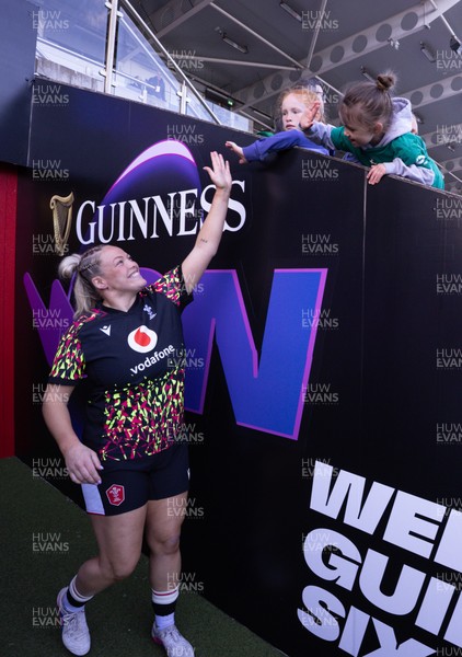 090526 - Ireland v Wales, 2026 Guinness Women’s 6 Nations - Kelsey Jones of Wales high fives a young fan as she makes her way to the pitch