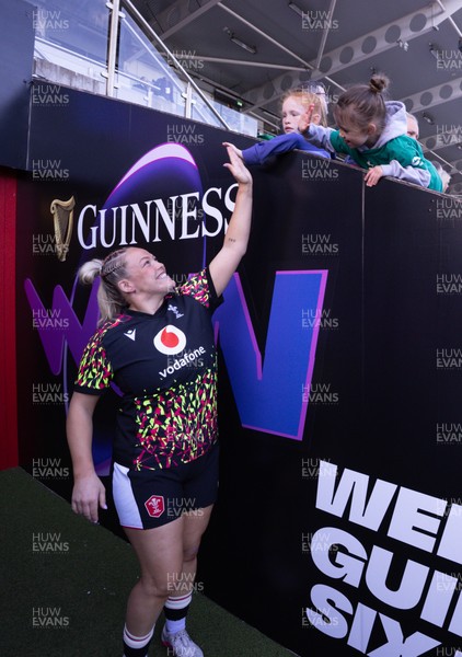090526 - Ireland v Wales, 2026 Guinness Women’s 6 Nations - Kelsey Jones of Wales high fives a young fan as she makes her way to the pitch