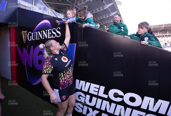 090526 - Ireland v Wales, 2026 Guinness Women’s 6 Nations - Kelsey Jones of Wales high fives a young fan as she makes her way to the pitch