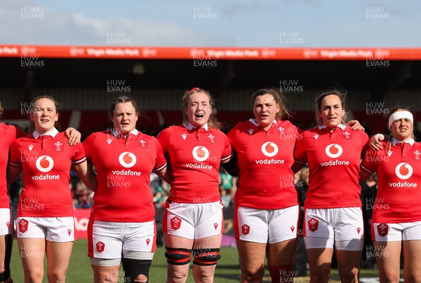 130424 - Ireland  v Wales, Guinness Women’s 6 Nations - Left to right, Jenny Hesketh, Abbey Constable, Abbie Fleming, Gwenllian Pyrs, Courtney Keight and Kayleigh Powell during the Welsh national anthem