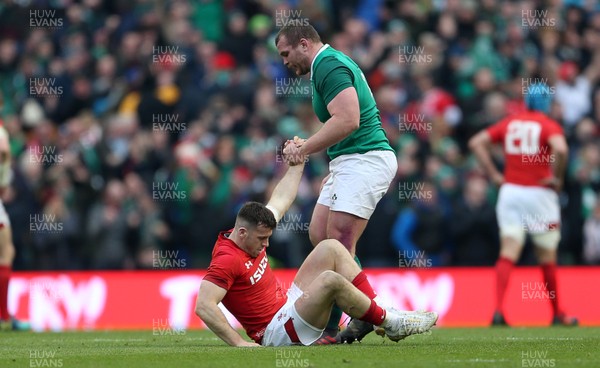 240218 - Ireland v Wales - Natwest 6 Nations - Gareth Davies of Wales is helped up by Jack McGrath of Ireland at full time