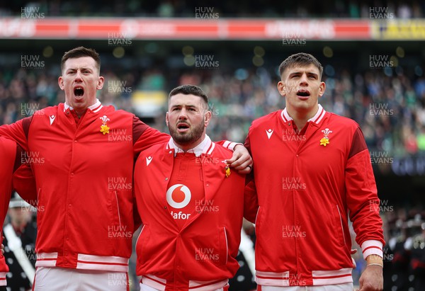 240224 - Ireland v Wales - Guinness 6 Nations Championship - Adam Beard, Gareth Thomas and Dafydd Jenkins of Wales sing the anthem