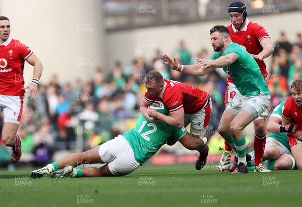 240224 - Ireland v Wales - Guinness 6 Nations Championship - Tommy Reffell of Wales is tackled by Bundee Aki of Ireland 