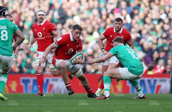240224 - Ireland v Wales - Guinness 6 Nations Championship - Alex Mann of Wales is challenged by Jack Crowley of Ireland 
