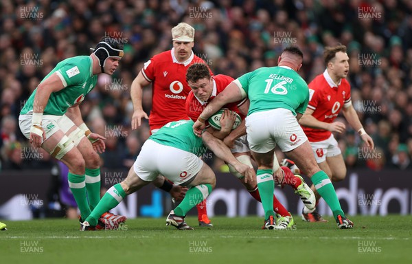 240224 - Ireland v Wales - Guinness 6 Nations Championship - Will Rowlands of Wales is tackled by Cian Healy and Ronan Kelleher of Ireland 