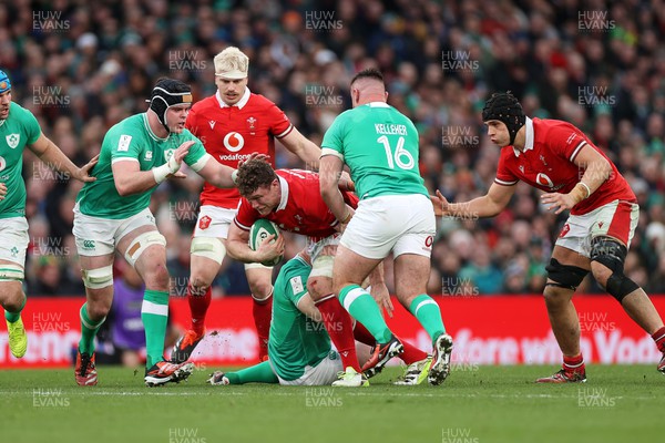 240224 - Ireland v Wales - Guinness 6 Nations Championship - Will Rowlands of Wales is tackled by Cian Healy and Ronan Kelleher of Ireland 