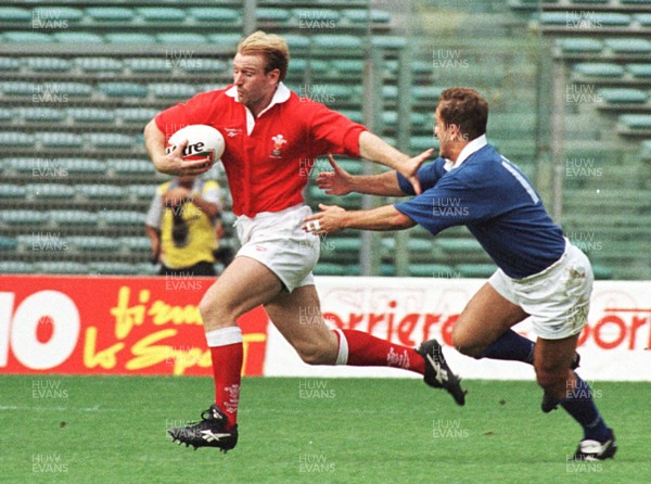 051096 - Italy v Wales - Double try scorer Gareth Thomas of Wales hands off Leonardo Manter and heads for the line