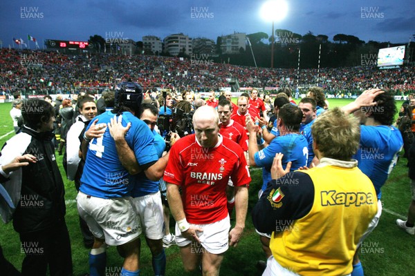 100307 - Italy v Wales - RBS Six Nations - Wales players leave the field dejected as Italian players celebrate 