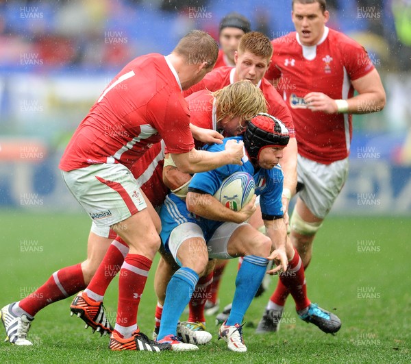 230213 - Italy v Wales - RBS Six Nations -Kristopher Burton of Italy is tackled by Gethin Jenkins and Richard Hibbard of Wales