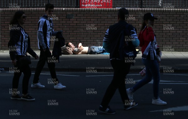 030617 - UEFA Champions League Final - Real Madrid v Juventus - A man takes a nap in a patch of sun outside the stadium