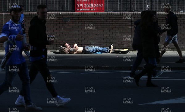 030617 - UEFA Champions League Final - Real Madrid v Juventus - A man takes a nap in a patch of sun outside the stadium