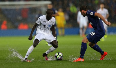 270816 - Leicester City v Swansea City - Premier League - Modou Barrow of Swansea City and Christian Fuchs of Leicester battle the conditions