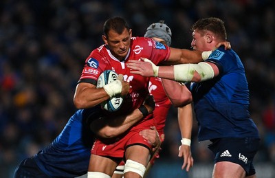 161021 - Leinster v Scarlets - United Rugby Championship - Aaron Shingler of Scarlets is tackled by Caelan Doris, left, and Tadhg Furlong of Leinster