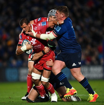 161021 - Leinster v Scarlets - United Rugby Championship - Aaron Shingler of Scarlets is tackled by Caelan Doris, left, and Tadhg Furlong of Leinster