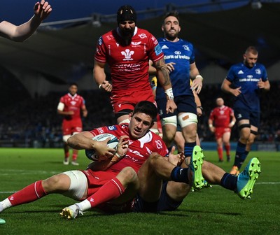 161021 - Leinster v Scarlets - United Rugby Championship - Tomas Lezana of Scarlets dives over to score his side's second try despite the tackle of Josh van der Flier of Leinster