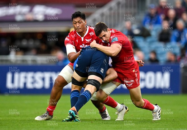 161021 - Leinster v Scarlets - United Rugby Championship - Ross Molony of Leinster is tackled by Sam Lousi, left, and Tomas Lezana of Scarlets