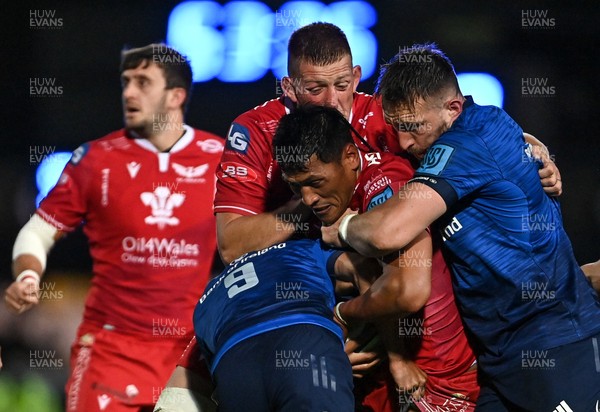 161021 - Leinster v Scarlets - United Rugby Championship - Sam Lousi of Scarlets is tackled by Jamison Gibson-Park, left, and Jack Conan of Leinster