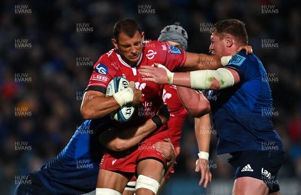 161021 - Leinster v Scarlets - United Rugby Championship - Aaron Shingler of Scarlets is tackled by Caelan Doris, left, and Tadhg Furlong of Leinster