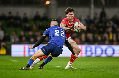 270326 - Leinster v Scarlets - United Rugby Championship - Joe Roberts of Scarlets is tackled by Sam Prendergast of Leinster 