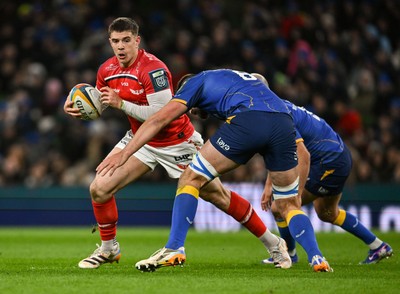 270326 - Leinster v Scarlets - United Rugby Championship - Joe Hawkins of Scarlets is tackled by Max Deegan and Jamison Gibson-Park of Leinster 