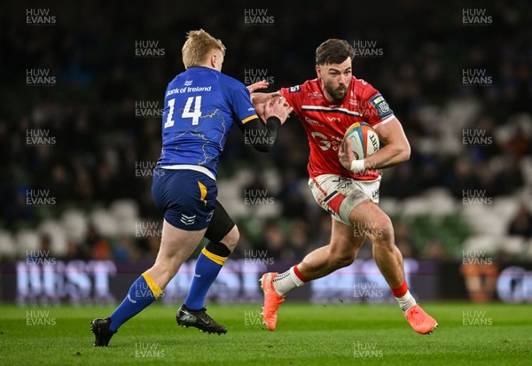 270326 - Leinster v Scarlets - United Rugby Championship - Johnny Williams of Scarlets is challenged by Tommy O'Brien of Leinster 