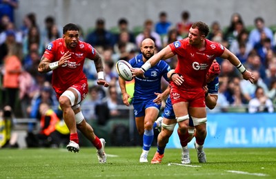 310525 - Leinster v Scarlets - United Rugby Championship Quarter-Final - Alex Craig of Scarlets offloads the ball to team-mate Vaea Fifita while under pressure from Josh van der Flier of Leinster