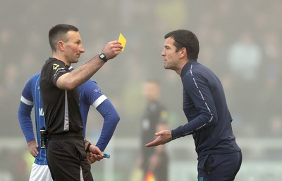 201225 - Lincoln City v Cardiff City - Sky Bet League 1 - Referee Richard Eley shows Manager Brian Barry-Murphy of Cardiff a yellow card in the 1st half