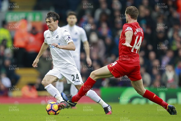 210117 - Liverpool v Swansea City, Premier League - Jack Cork of Swansea City (left) evades the tackle of  Jordan Henderson of Liverpool by Ian Smith/Huw Evans Agency